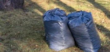 Full black trash bags in the park in early fall. Cleaning the park
